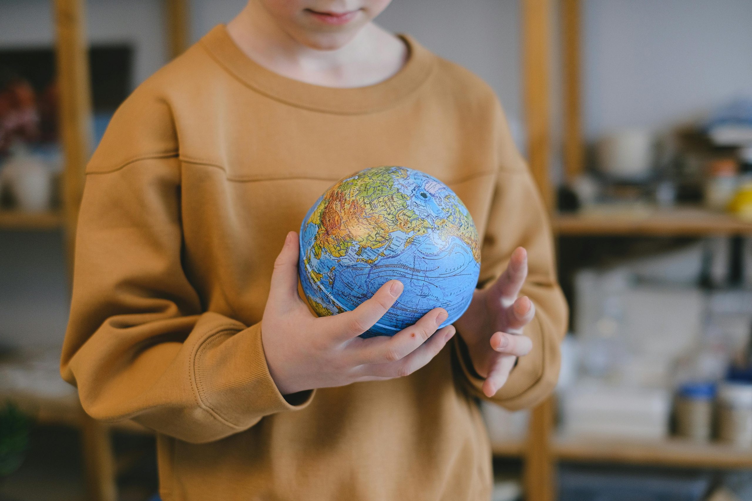 A child carefully holding a globe, symbolizing global education and exploration.